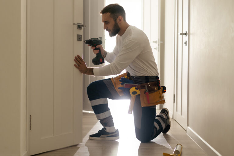 Portrait Young Male Carpenter Repairing Door Lock.